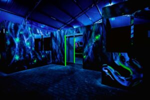 Laser tag arena for corporate events, group events. A laser tag arena in a dim room with colorful lights and obstacles.