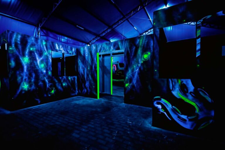 Laser tag arena for corporate events, group events. A laser tag arena in a dim room with colorful lights and obstacles.